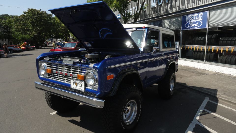 Blue Ford Bronco with hood open, parked outside a Westlie Ford dealership