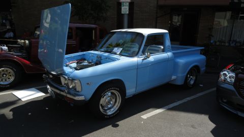 1964 Ford Fairlane - A light blue pickup truck with its hood open is parked at an outdoor event.