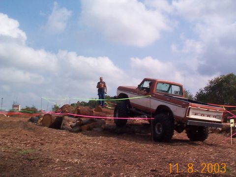 1992 Ford Bronco - A lifted Ford pickup truck navigates an off-road course marked with colorful ropes.