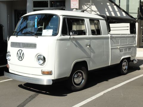 1964 Ford Fairlane - This white Volkswagen Type 2 pickup truck is seen from the front quarter, showing its distinctive front grille and headlights.