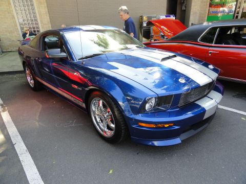 1964 Ford Fairlane - A blue Ford Mustang Shelby GT is parked next to a red classic car.
