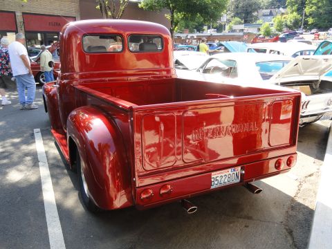 1964 Ford Fairlane - A shiny red International pickup truck is parked at an outdoor car show.