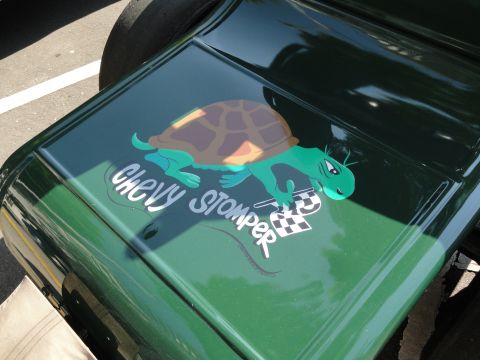 1964 Ford Fairlane - A cartoon turtle with a checkered flag is painted on the hood of a green vehicle.