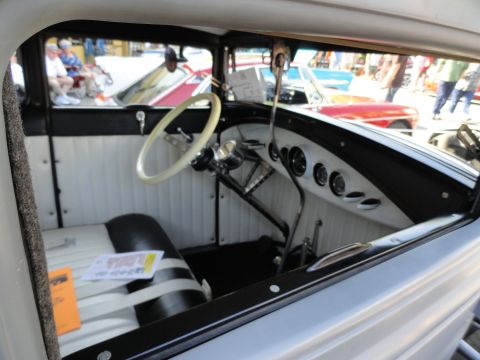 1964 Ford Fairlane - View of a classic car's interior, showing the dashboard and seats, with other vehicles in the background.