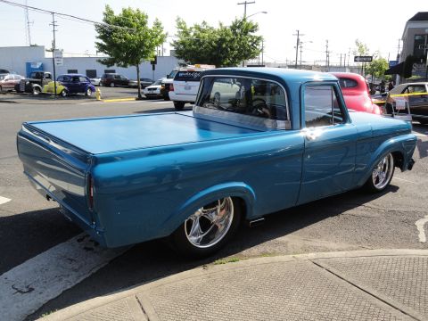1964 Ford Fairlane - A lowered blue pickup truck is parked curbside on a sunny day.