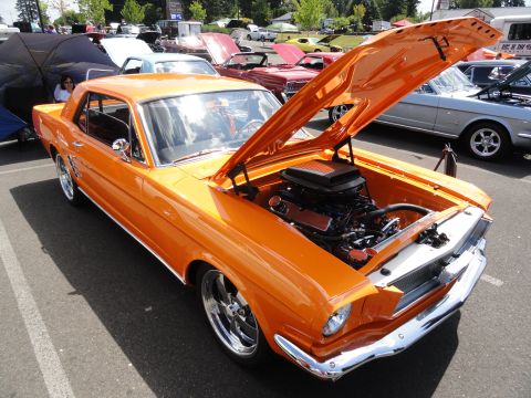 1964 Ford Fairlane - Orange 1965 Ford Mustang coupe at a car show, hood open to display the engine.