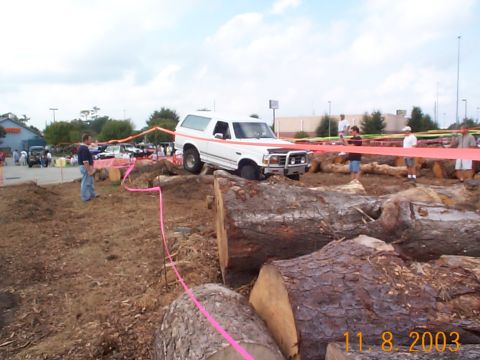 1992 Ford Bronco - White 1992 Ford Bronco tackles a challenging obstacle course made of large logs.