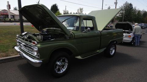 1964 Ford Fairlane - A green 1965 Ford F-series pickup truck is displayed with its hood and bed open.