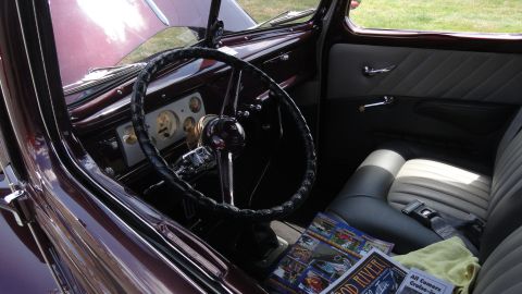 1964 Ford Fairlane - Interior view of a classic car, a detailed dashboard and seating area with magazines.