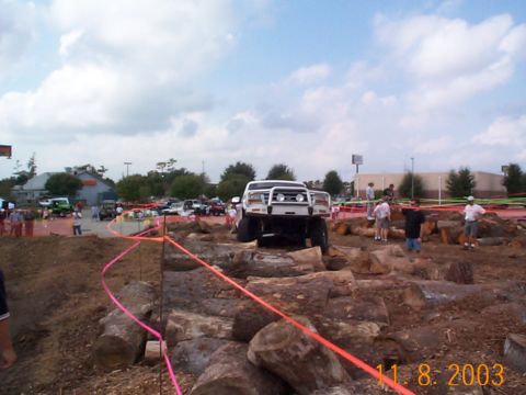 1992 Ford Bronco - A white 1992 Ford Bronco navigates a challenging obstacle course made of logs.