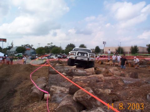 1992 Ford Bronco - SUV attempts to clear a log obstacle during an off-road event.