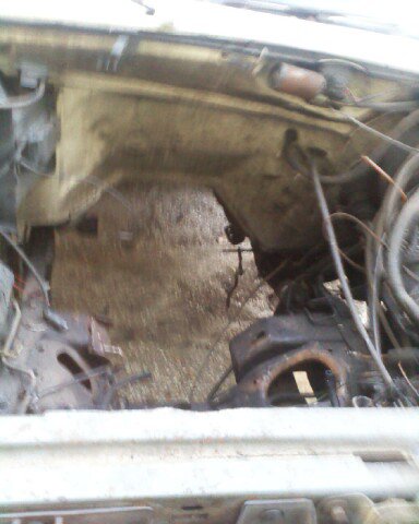 1988 Ford Bronco - The engine bay of a vehicle, showing various mechanical parts and wiring harnesses.