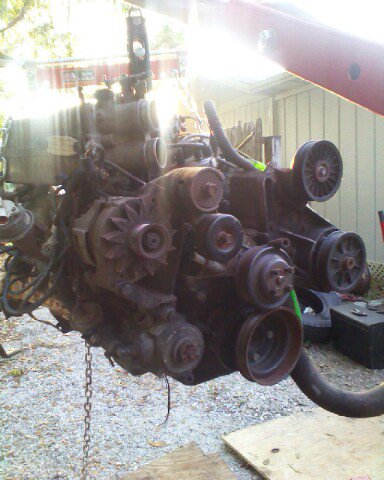 1988 Ford Bronco - This engine is suspended by a chain and crane, revealing its internal components and accessory drive system.