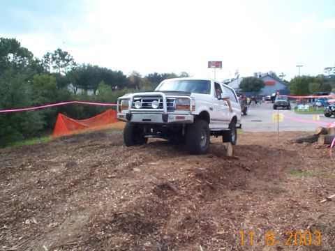 1992 Ford Bronco - A white Ford Bronco navigates an off-road obstacle course with other vehicles present.