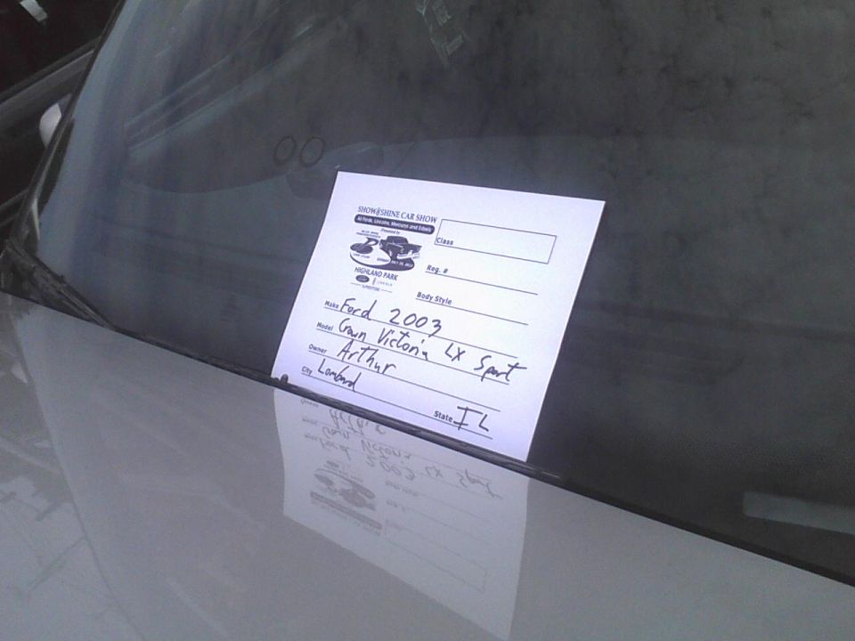 Car show sign on windshield lists Ford 2003 Crown Victoria LX Sport