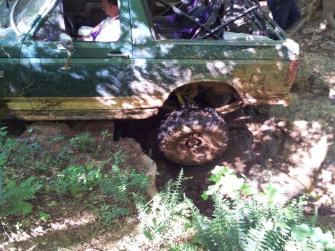 2012 Ford Bronco - Off-road SUV navigating rocky terrain, mud splattered on its body and tires.
