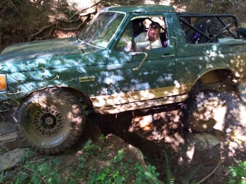 2012 Ford Bronco - This green Bronco is navigating a rocky trail with a roll cage installed for off-road safety.