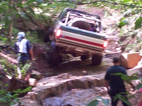 2012 Ford Bronco - This vehicle is tackling a challenging off-road course with spectators observing the difficult terrain.