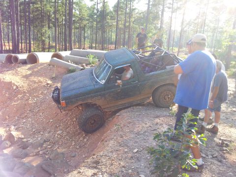 2012 Ford Bronco - Modified Ford Bronco navigates an off-road obstacle course with spectators watching.