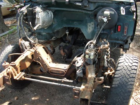 1995 Ford Bronco - The vehicle's frame and engine bay are exposed, showing significant rust and missing parts.