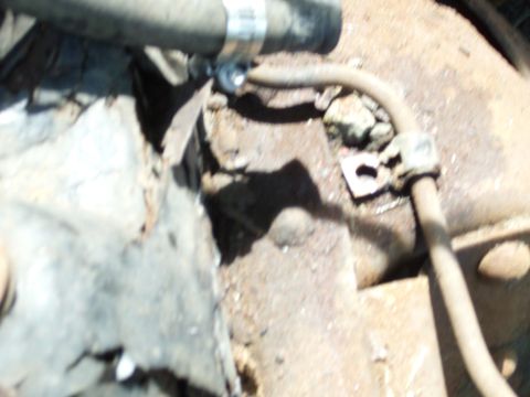 1995 Ford Bronco - Close-up view of corroded engine and transmission components, including hoses and clamps.