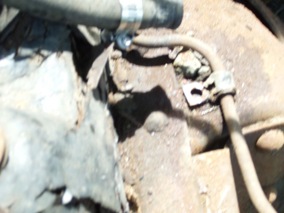 Rusty engine and transmission parts with hoses and clamps