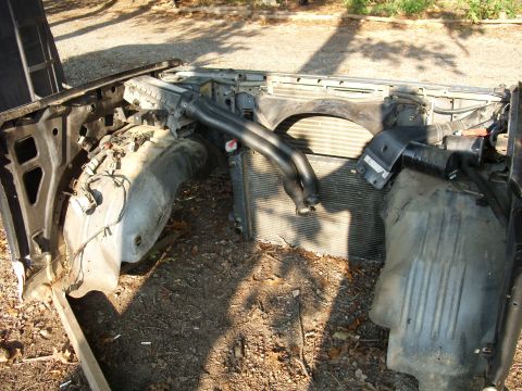 1988 Ford Bronco - The front clip of a vehicle has been removed, exposing the radiator and associated components.