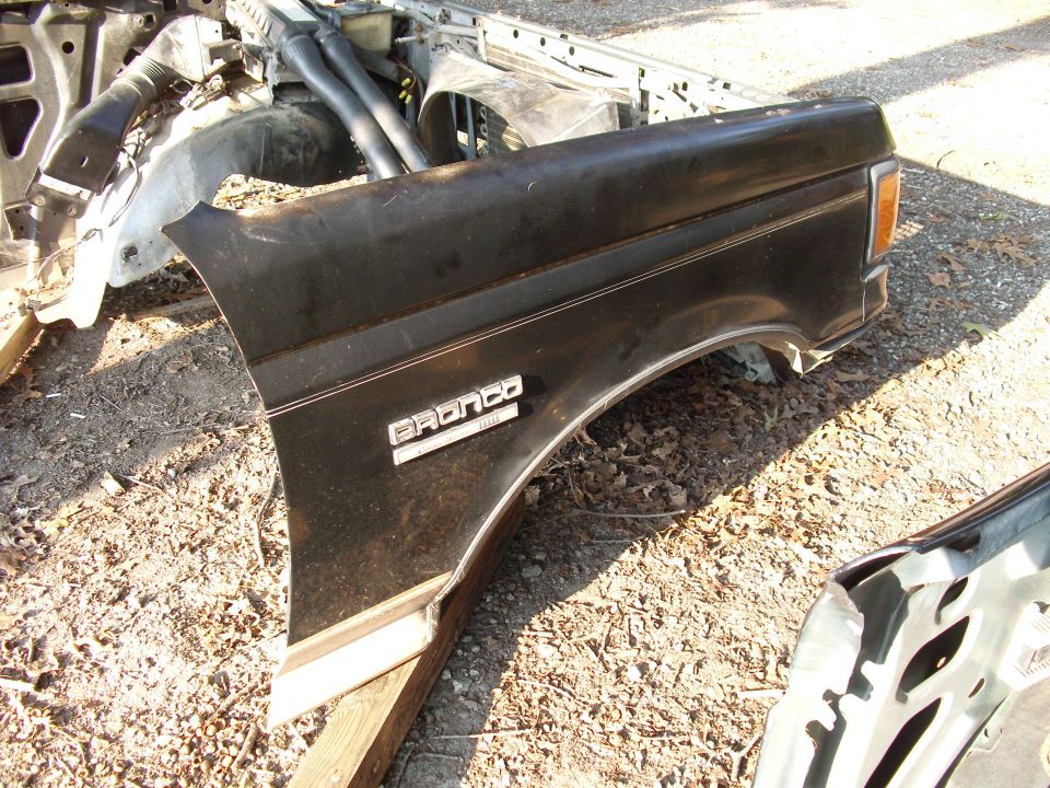 Black Bronco fender with chrome trim and badge, attached to chassis parts