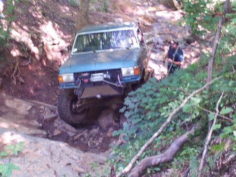 1979 Ford F-150 - A blue off-road vehicle navigates a challenging rocky terrain.