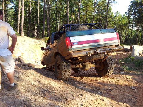 1979 Ford F-150 - This Ford F-Series truck, likely from the late 1980s, tackles a challenging off-road course with a custom roll cage.