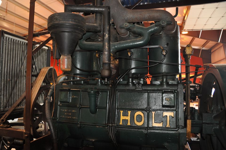 Green engine block with gold "HOLT" lettering and various pipes and filters