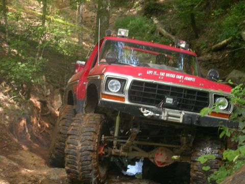 1990 Ford Bronco - This modified 1979 Ford F-Series truck navigates a steep, muddy incline in a wooded area.