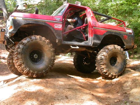 1990 Ford Bronco - This heavily modified Ford Bronco is equipped for extreme off-roading with its oversized tires and protective roll cage.