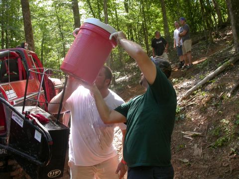 1990 Ford Bronco - Off-roading group takes a break to rehydrate with water from a large jug.