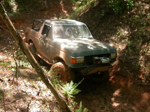 1990 Ford Bronco - This 1990 Ford Bronco navigates a challenging off-road trail, equipped with a winch for assistance.