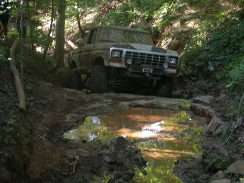 1990 Ford Bronco - Ford Bronco tackling a difficult muddy obstacle course.