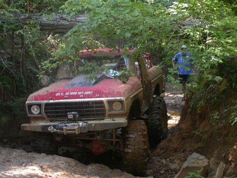 1990 Ford Bronco - This heavily modified Ford Bronco is deep in the mud on an off-road trail.