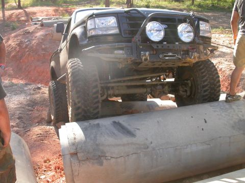 1990 Ford Bronco - A modified black Ford Bronco navigates a challenging off-road course.