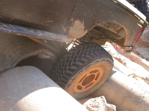 1990 Ford Bronco - This vehicle is shown in a challenging off-road environment, with its tires positioned over large rocks.