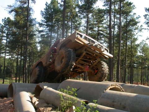 1990 Ford Bronco - This heavily modified truck is navigating a challenging obstacle course made of concrete pipes.