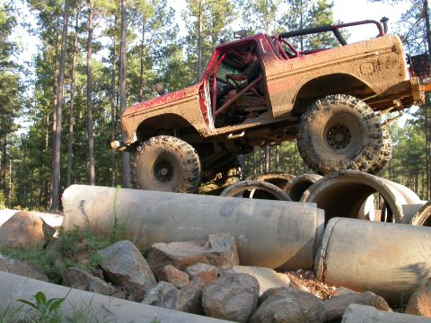 1990 Ford Bronco - This heavily modified SUV is navigating a challenging obstacle course.