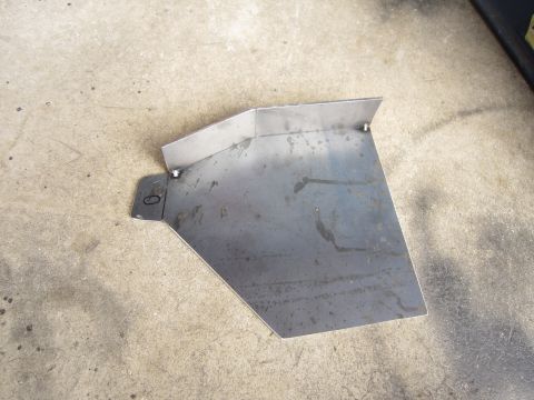 2008 Jeep Wrangler - A custom-fabricated metal bracket, likely for automotive use, rests on a textured concrete surface.