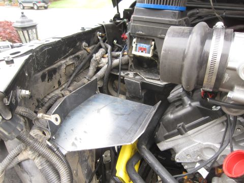 2008 Jeep Wrangler - Custom metal bracket installed in the engine bay of a vehicle, with another vehicle in the background.