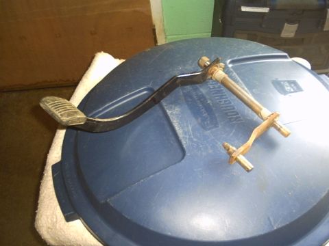 1991 Ford LTD Crown Victoria - A removed brake pedal arm with ribbed rubber pad rests on a blue Roughneck tote lid, its curved black lever attached to a pivot shaft with…
