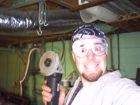1991 Ford LTD Crown Victoria - A person in a black bandana and clear safety goggles grins at the camera while holding up a Black & Decker angle grinder with a worn cutoff…