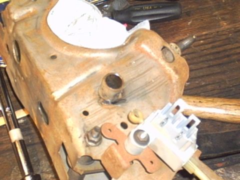 1991 Ford LTD Crown Victoria - Close-up of a rusty metal component with an electrical connector attached, resting on a wooden surface.