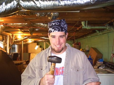 1991 Ford LTD Crown Victoria - A man wearing a bandana and holding a sledgehammer poses for a photo in a cluttered basement.