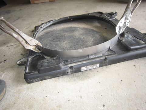 2008 Jeep Wrangler - A radiator fan shroud is modified with a metal band, held in place by locking pliers.