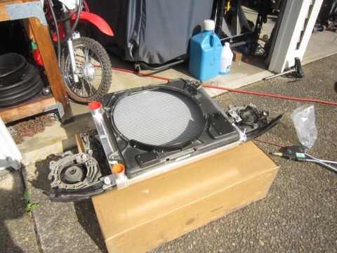 2008 Jeep Wrangler - Engine parts, including a radiator, are laid out on a driveway.