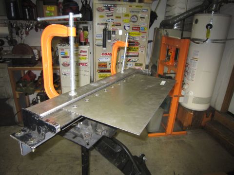 2008 Jeep Wrangler - Metal sheet secured with clamps on a workbench, ready for fabrication.
